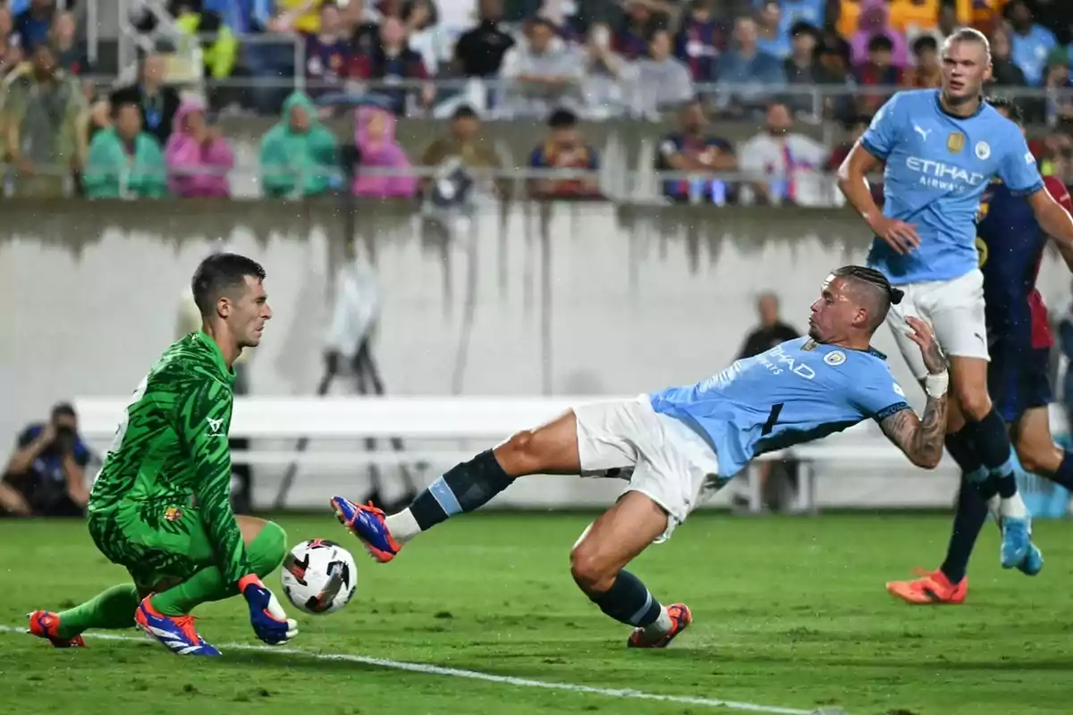 Un portero y un jugador de fútbol disputan el balón en un partido bajo la lluvia, mientras otro jugador observa la acción. Un portero y un jugador de fútbol disputan el balón en un partido bajo la lluvia, mientras otro jugador observa la acción.