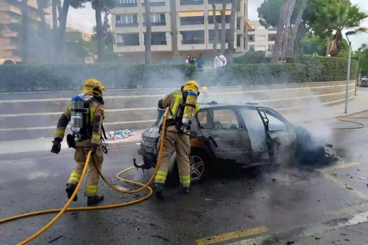 Imatge dels Bombers apagant el foc d´un cotxe totalment calcinat a Salou