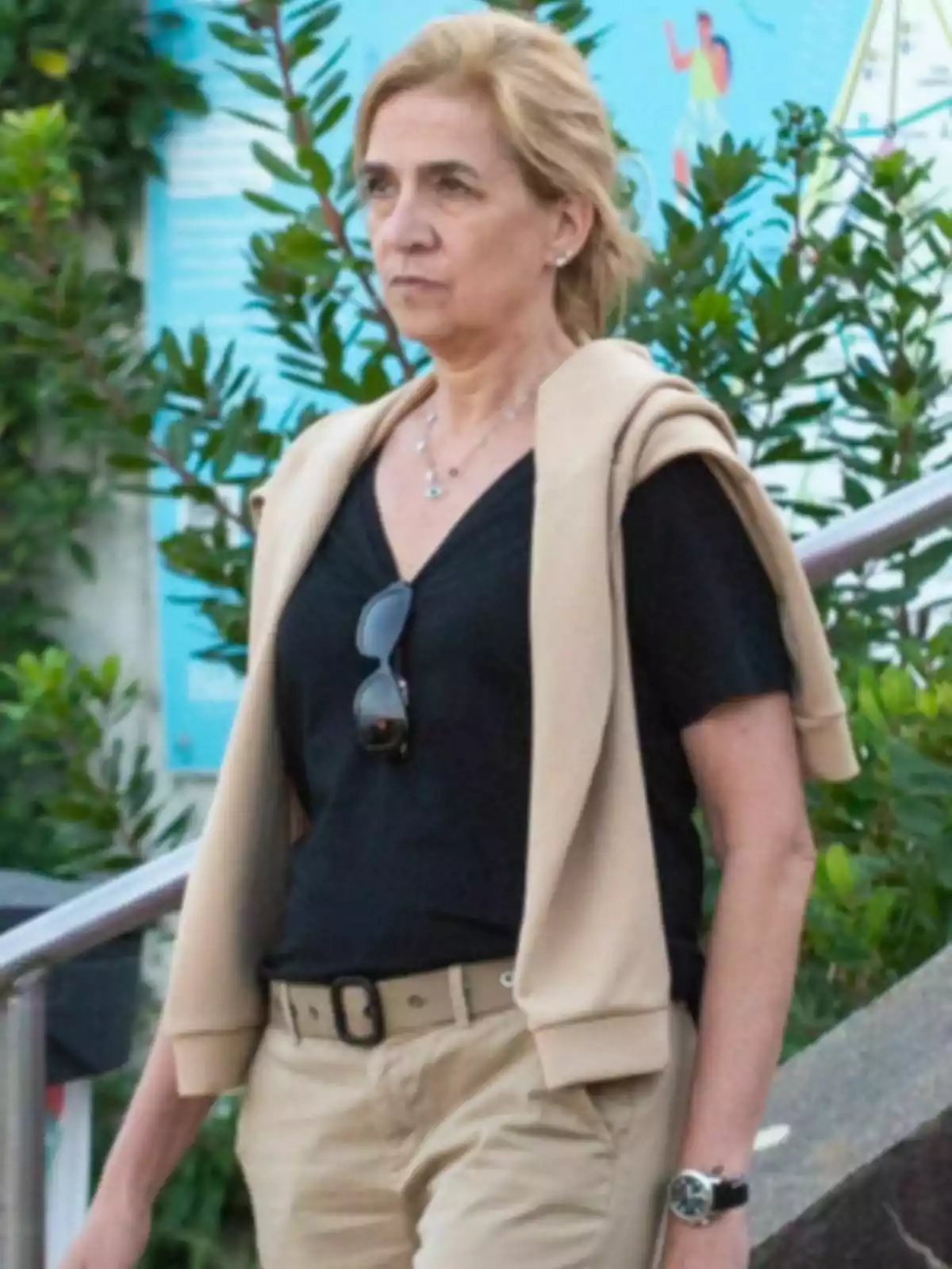 La infanta Cristina d’expressió seriosa caminant a l’aire lliure amb pantalons beix, samarreta negra i jersei clar sobre les espatlles. La infanta Cristina d’expressió seriosa caminant a l’aire lliure amb pantalons beix, samarreta negra i jersei clar sobre les espatlles.