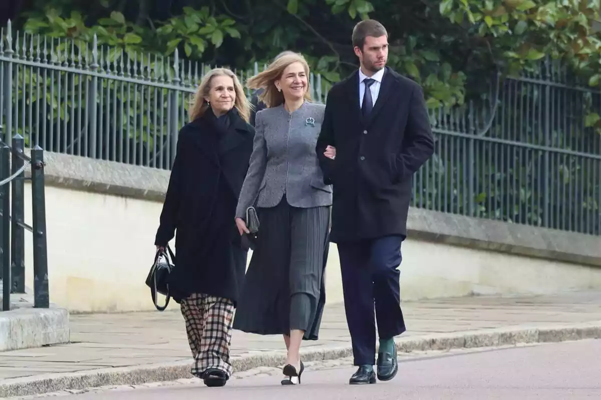 La infanta Elena amb un abric gris i uns pantalons de quadres, la infanta Cristina somrient amb un vestit gris i Juan Urdangarin seriós amb un vestit negre La infanta Elena amb un abric gris i uns pantalons de quadres, la infanta Cristina somrient amb un vestit gris i Juan Urdangarin seriós amb un vestit negre