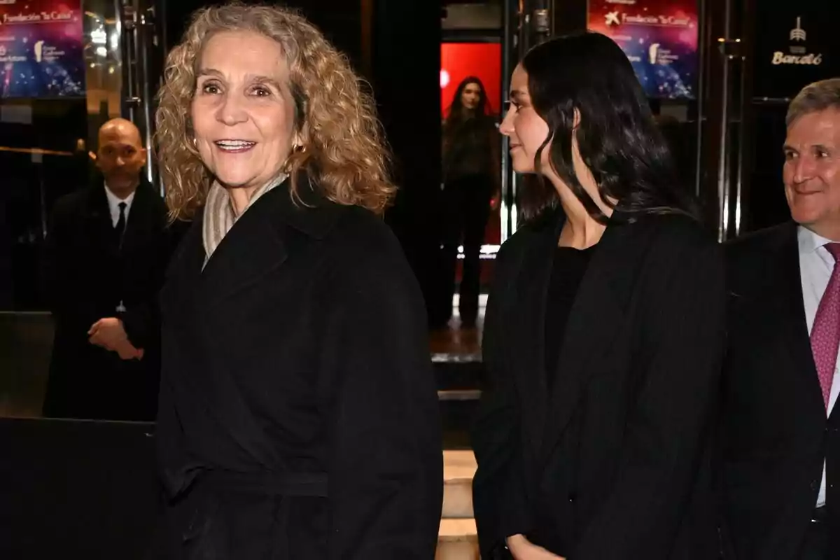 La infanta Elena i Victoria Federica somrient i conversant en un esdeveniment formal. La infanta Elena i Victoria Federica somrient i conversant en un esdeveniment formal.