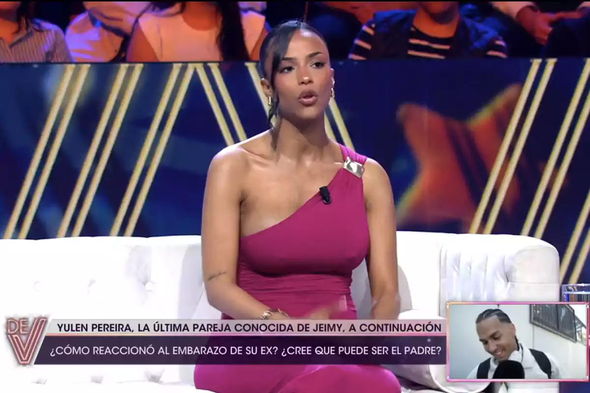 Jeimy Báez amb un vestit rosa està asseguda en un sofà blanc en un programa de televisió. A la part inferior de la imatge hi ha un text que esmenta a Yulen Pereira i una pregunta sobre l'embaràs de la seva ex. A la cantonada inferior dreta hi ha una petita imatge d'un home somrient. Jeimy Báez amb un vestit rosa està asseguda en un sofà blanc en un programa de televisió. A la part inferior de la imatge hi ha un text que esmenta a Yulen Pereira i una pregunta sobre l'embaràs de la seva ex. A la cantonada inferior dreta hi ha una petita imatge d'un home somrient.