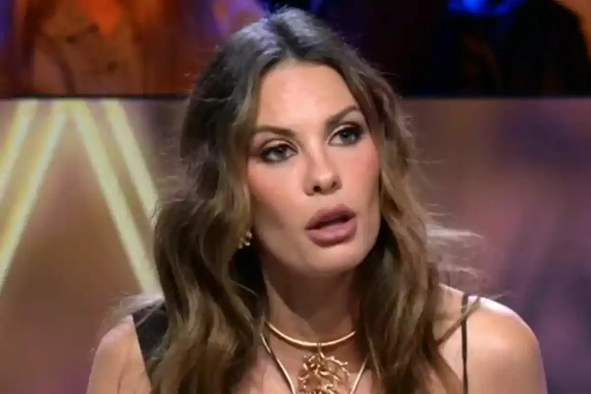 Jessica Bueno amb cabell llarg i ondulat i expressió seriosa està en un entorn il·luminat a De Viernes. Jessica Bueno amb cabell llarg i ondulat i expressió seriosa està en un entorn il·luminat a De Viernes.
