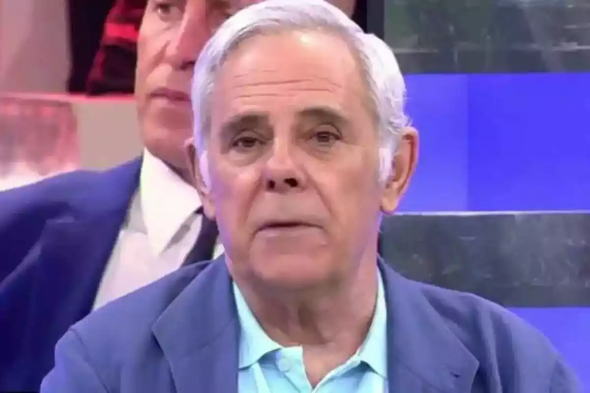 Jimmy Giménez-Arnau amb cabell canós i expressió seriosa, vestit amb una jaqueta blava i una camisa celeste, apareix en un programa de televisió.