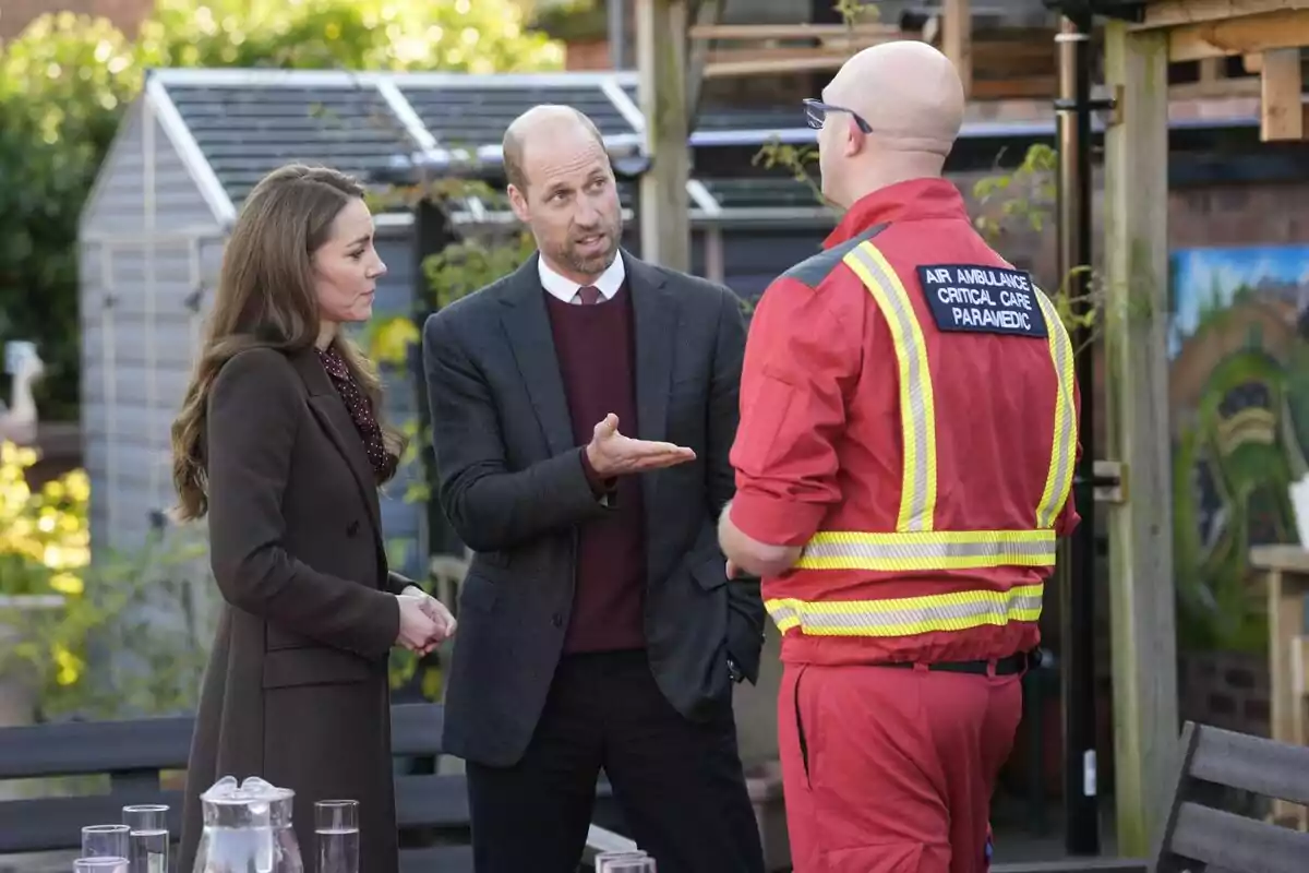Kate Middleton and Prince William chat with an air ambulance critical care paramedic in an outdoor setting. Kate Middleton and Prince William chat with an air ambulance critical care paramedic in an outdoor setting.