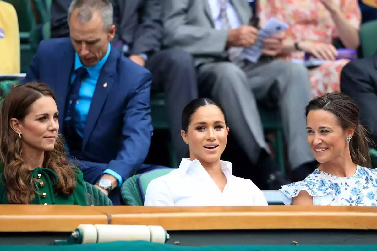 Kate Middleton seriosa amb una brusa verda, Meghan Markle parlant amb una camisa blanca i Pippa Middleton rient amb una brusa de flors Kate Middleton seriosa amb una brusa verda, Meghan Markle parlant amb una camisa blanca i Pippa Middleton rient amb una brusa de flors