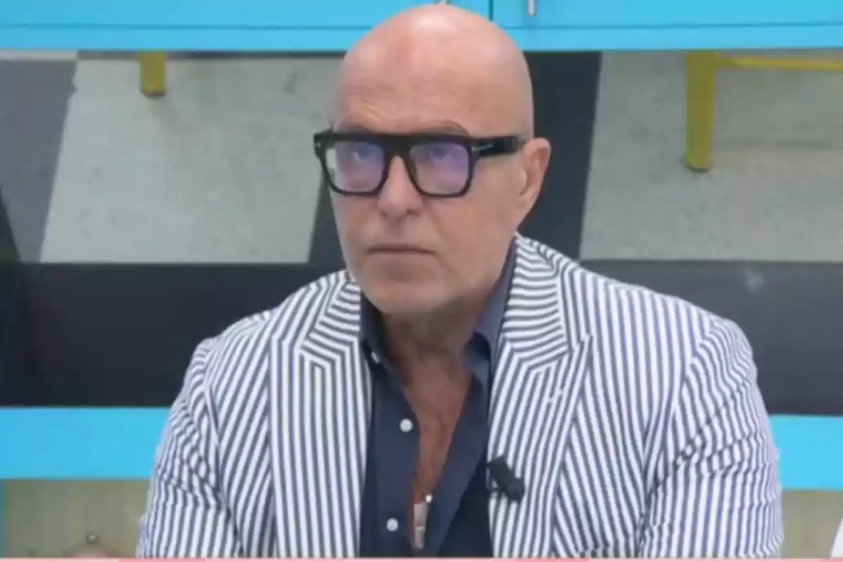 Kiko Matamoros calb amb ulleres i jaqueta de ratlles blanques i blaves assegut en un ambient interior a 'La família de la tele'. Kiko Matamoros calb amb ulleres i jaqueta de ratlles blanques i blaves assegut en un ambient interior a 'La família de la tele'.