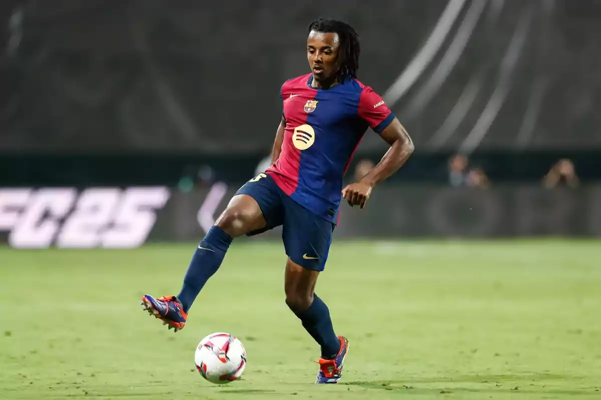 Soccer player in blue and red uniform controlling the ball on the playing field. Soccer player in blue and red uniform controlling the ball on the playing field.
