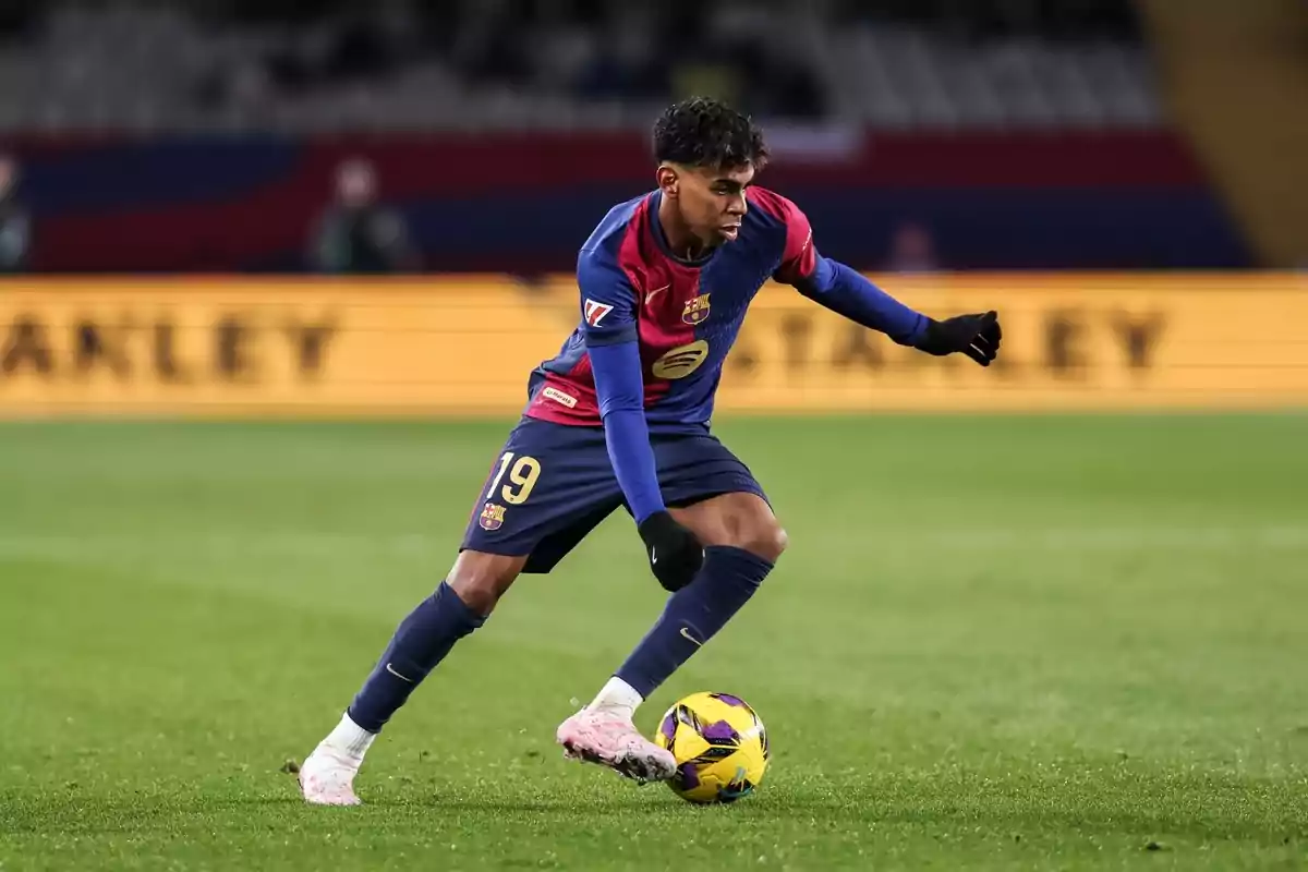 Jugador de futbol en acció durant un partit, vestint l'uniforme del FC Barcelona i controlant la pilota al camp. Jugador de futbol en acció durant un partit, vestint l'uniforme del FC Barcelona i controlant la pilota al camp.