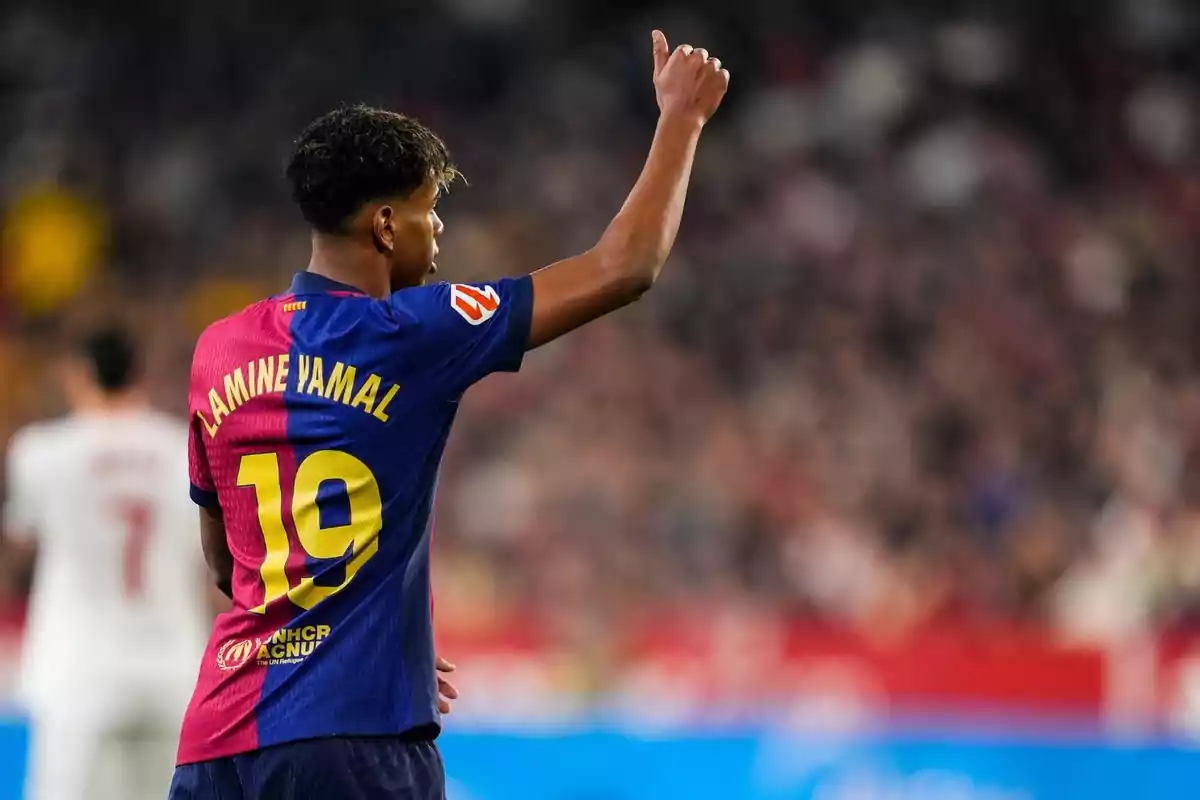 A player with the number 19 on his jersey raises his arm in a stadium. A player with the number 19 on his jersey raises his arm in a stadium.