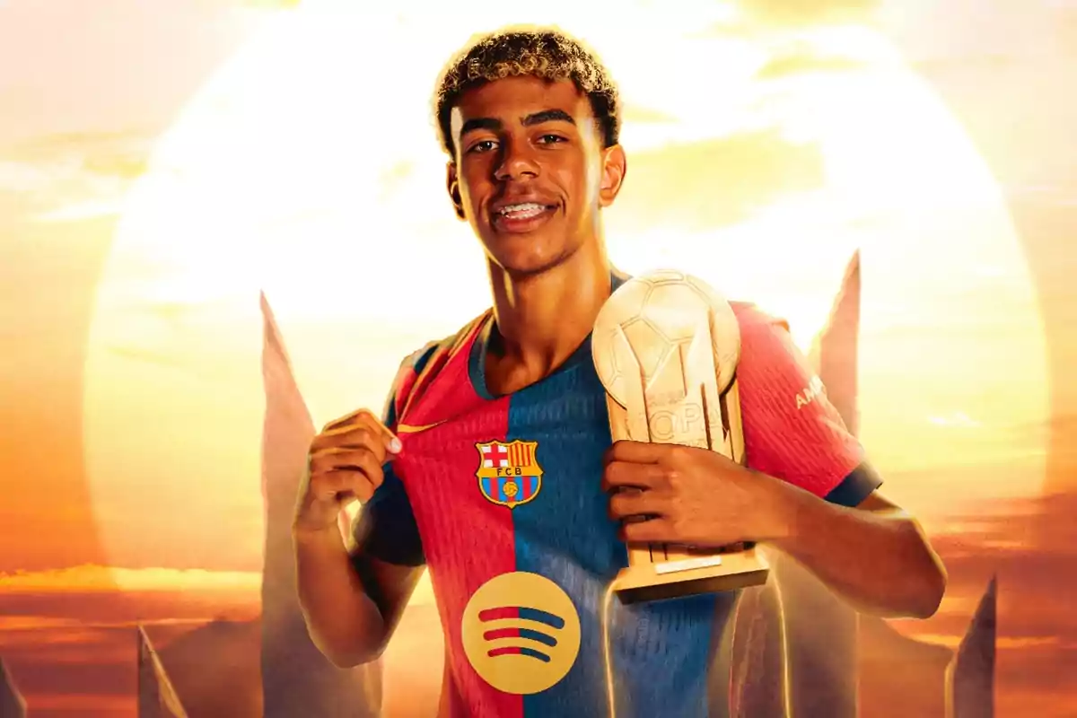 Un jugador de fútbol con uniforme del FC Barcelona sostiene un trofeo mientras sonríe frente a un fondo de atardecer.