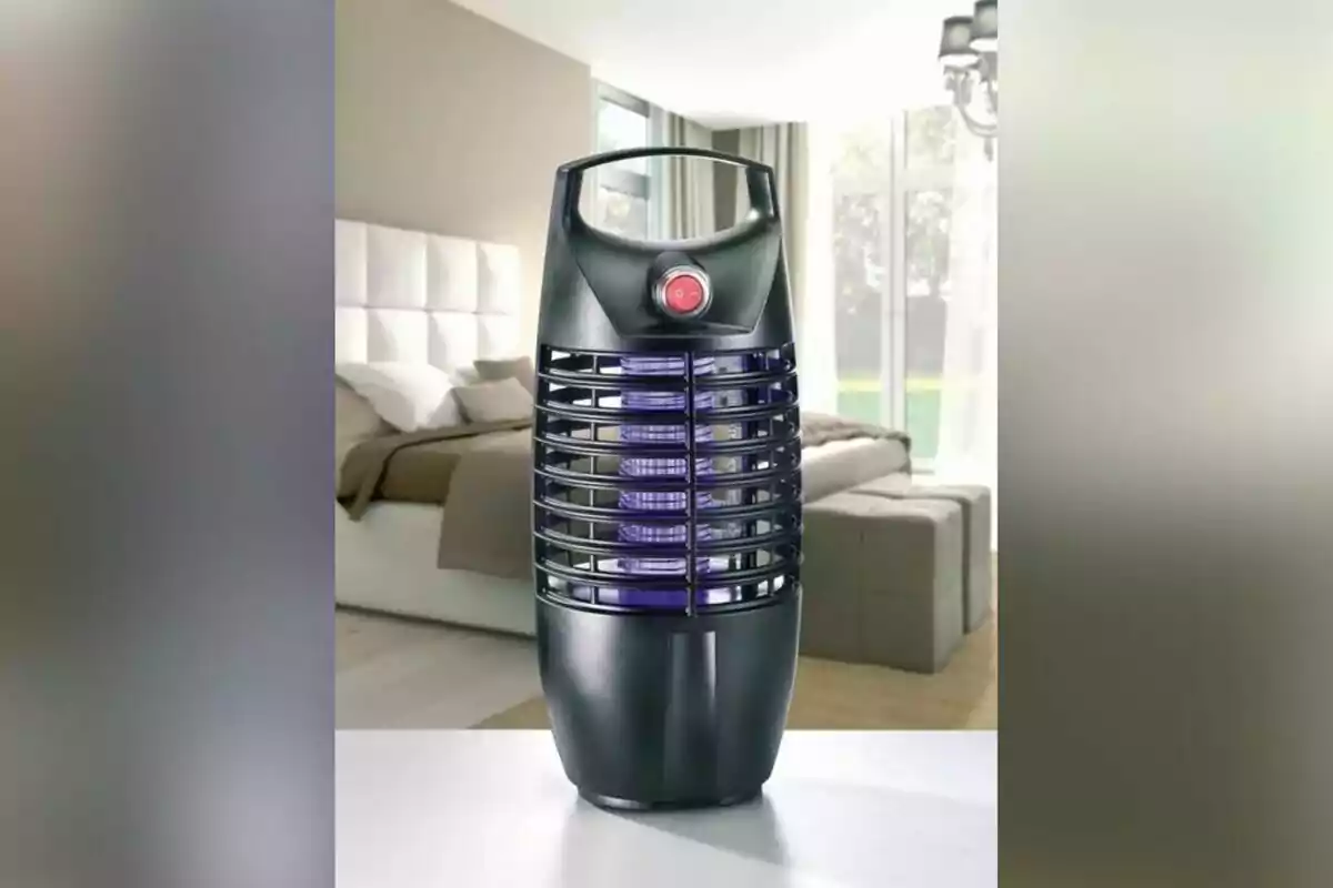 Un dispositiu elèctric negre amb reixetes i un botó vermell en un dormitori modern. Un dispositiu elèctric negre amb reixetes i un botó vermell en un dormitori modern.