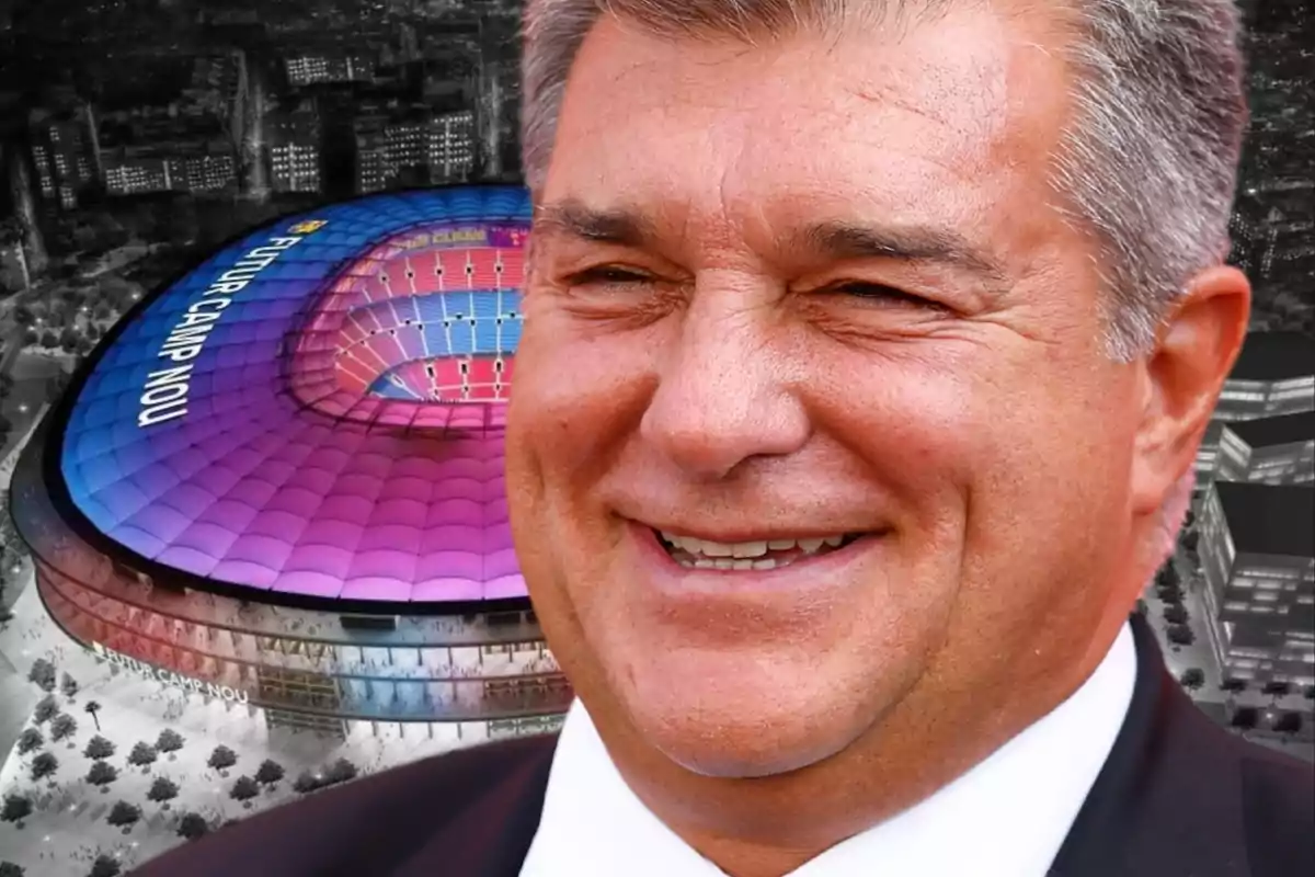 A smiling man in the foreground with a lit-up stadium in the background.