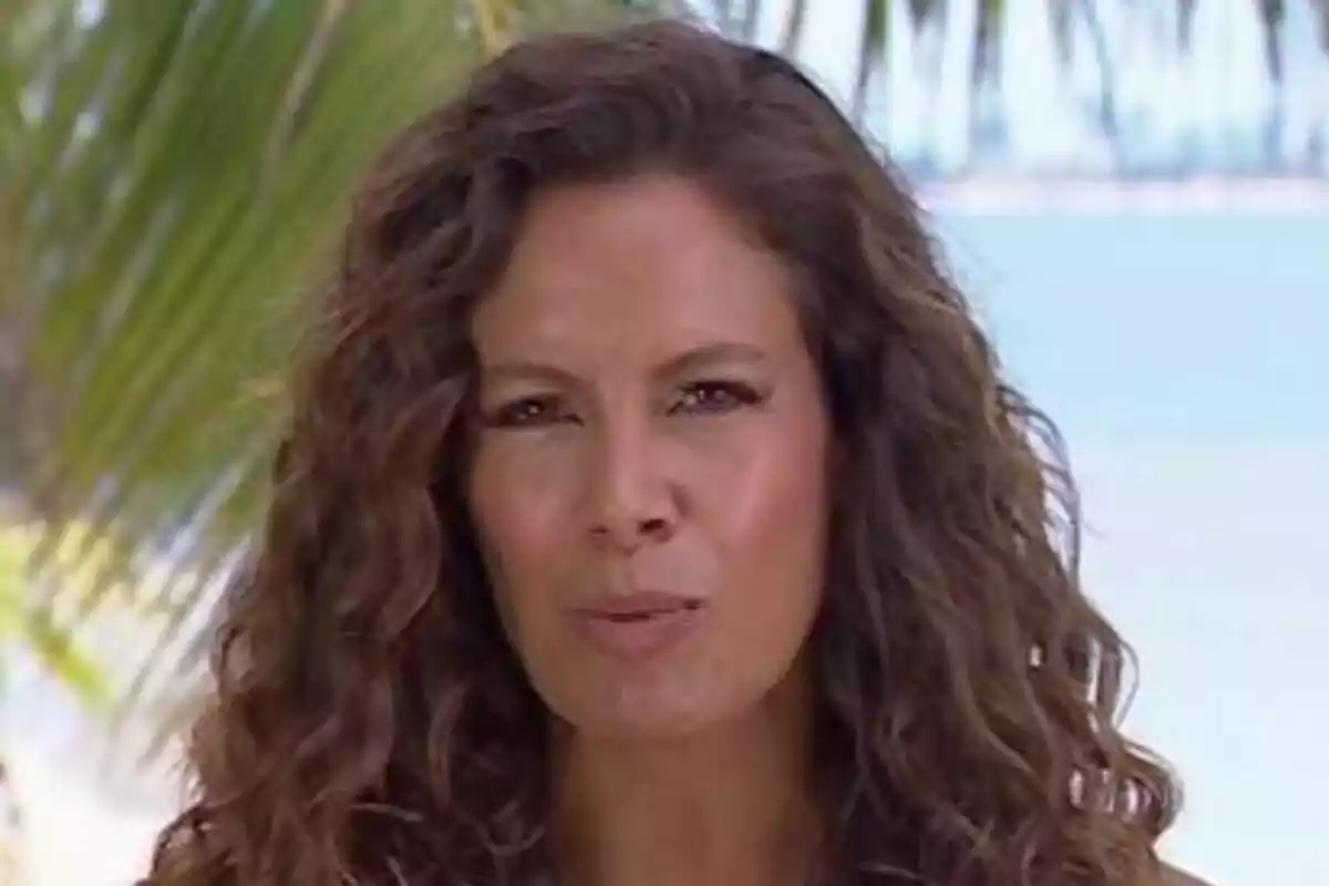 Laura Madrueño amb cabell arrissat i expressió seriosa en un entorn tropical amb palmeres i el mar de fons a Supervivientes. Laura Madrueño amb cabell arrissat i expressió seriosa en un entorn tropical amb palmeres i el mar de fons a Supervivientes.