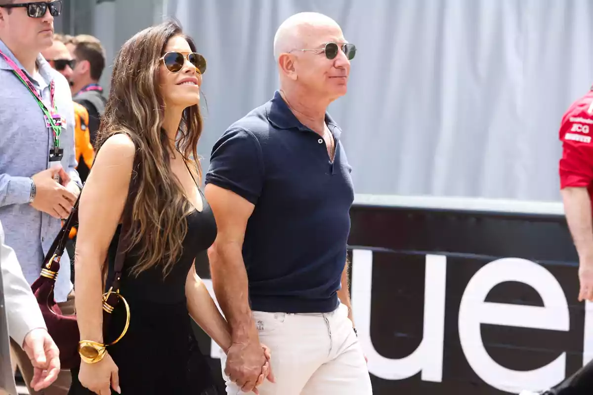 Lauren Sánchez y Jeff Bezos caminando de la mano al aire libre ambos usando gafas de sol y ropa casual Lauren Sánchez y Jeff Bezos caminando de la mano al aire libre ambos usando gafas de sol y ropa casual