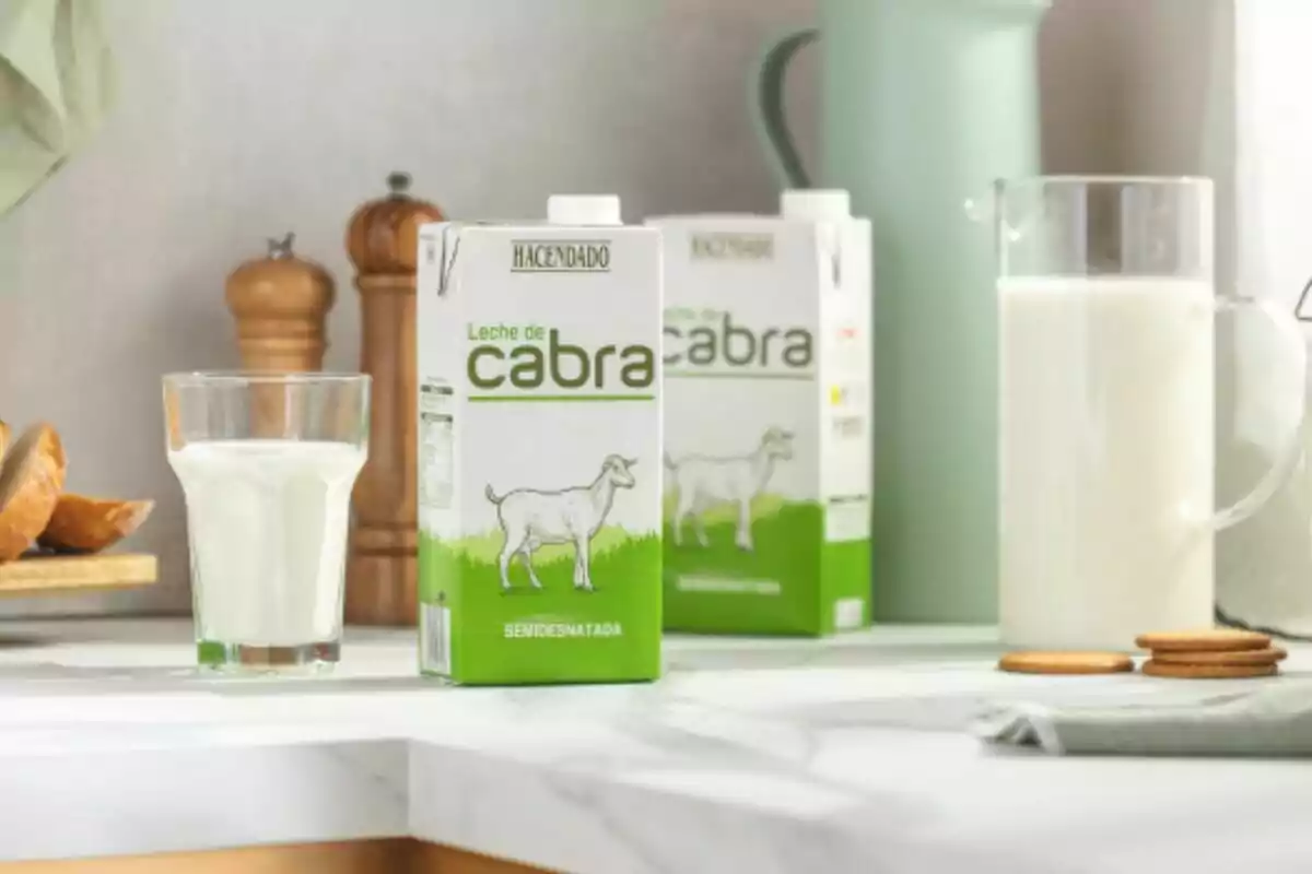 Caixa de llet de cabra semidesnatada de la marca Hacendado sobre una taula al costat d'un got de llet, una gerra i algunes galetes. Caixa de llet de cabra semidesnatada de la marca Hacendado sobre una taula al costat d'un got de llet, una gerra i algunes galetes.