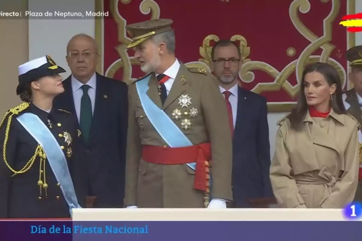 Leonor listening to the instructions of her father, Felipe VI, together with Queen Letizia, dressed in a beige trench coat, on Hispanic Day 2024 Leonor listening to the instructions of her father, Felipe VI, together with Queen Letizia, dressed in a beige trench coat, on Hispanic Day 2024