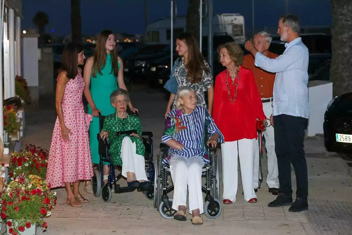 The Spanish royal family, with Irene of Greece and Tatiana Redziwill in wheelchairs, chatting outdoors at night. The Spanish royal family, with Irene of Greece and Tatiana Redziwill in wheelchairs, chatting outdoors at night.