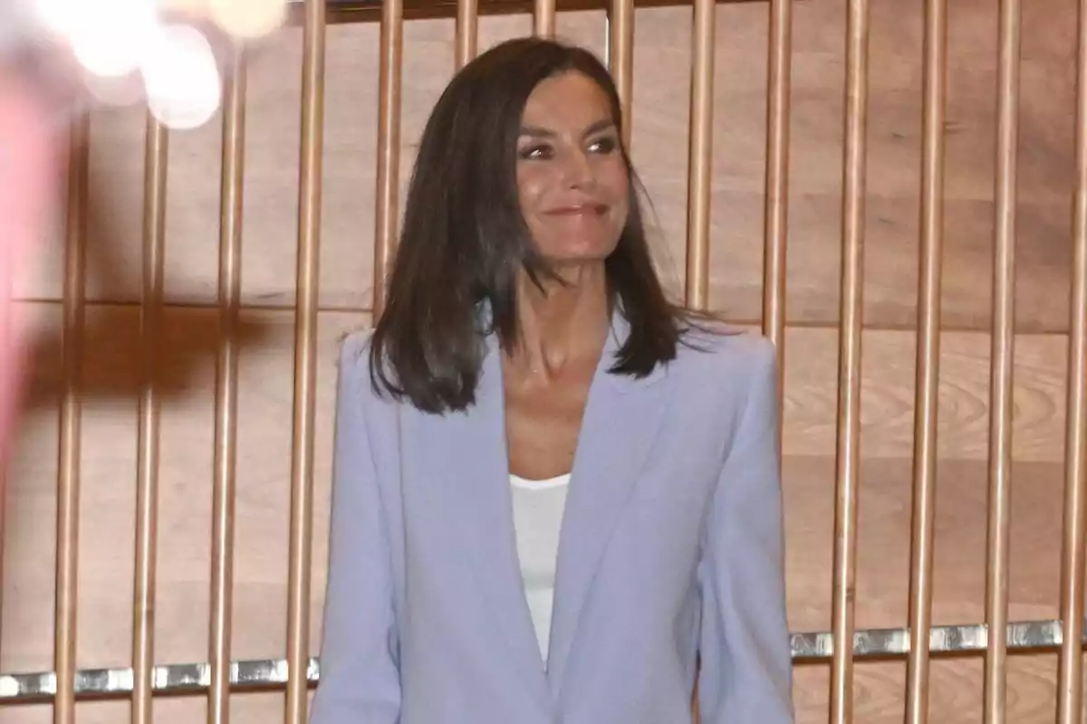 Letizia somrient mirant de banda amb un vestit morat Letizia somrient mirant de banda amb un vestit morat