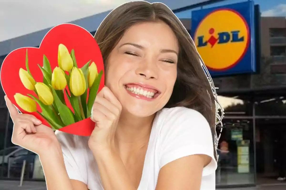 Una persona somrient sosté un ram de tulipes grocs en un cor vermell davant d'una botiga de Lidl.