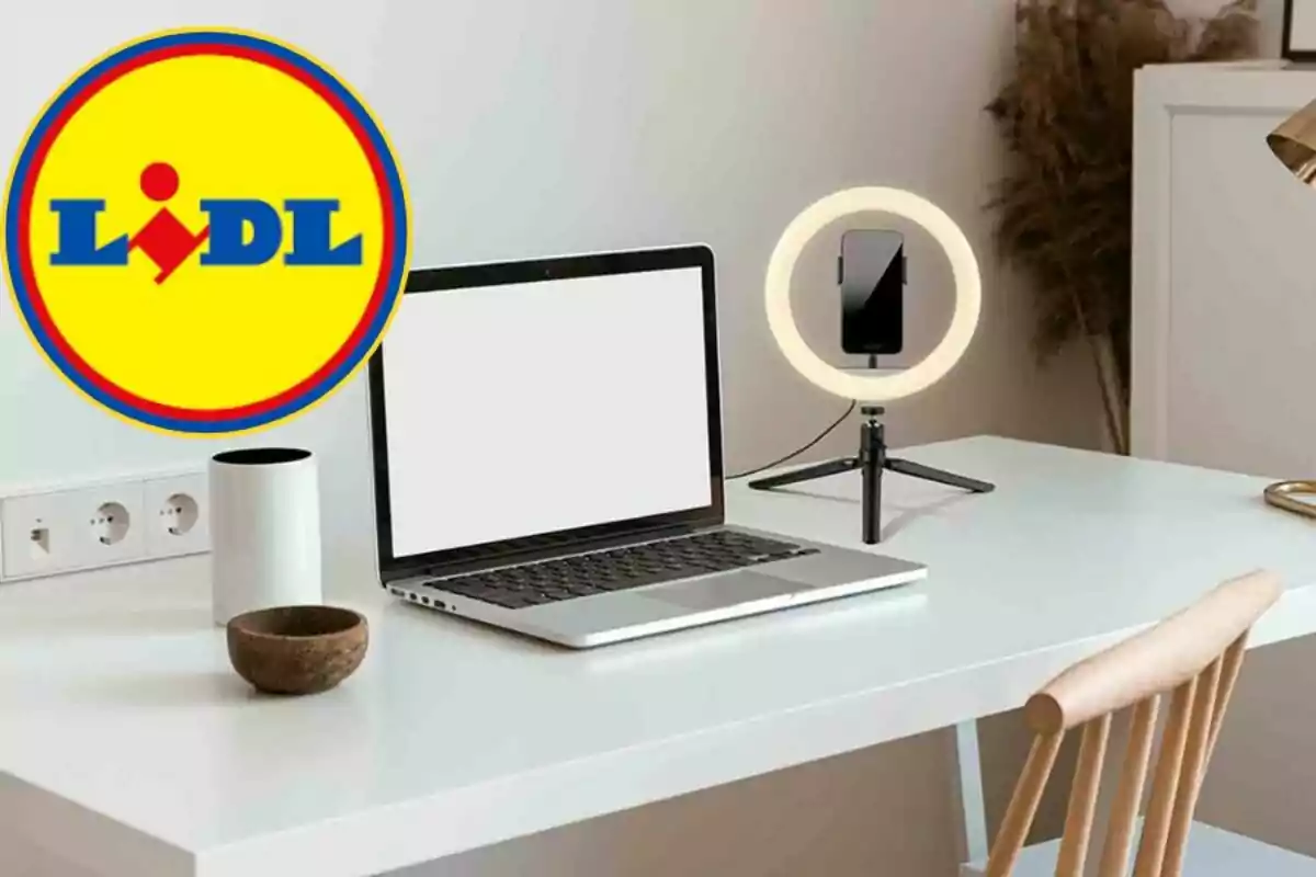 Una taula de treball amb un portàtil, un anell de llum amb suport per a telèfon i el logotip de Lidl a la cantonada superior esquerra.