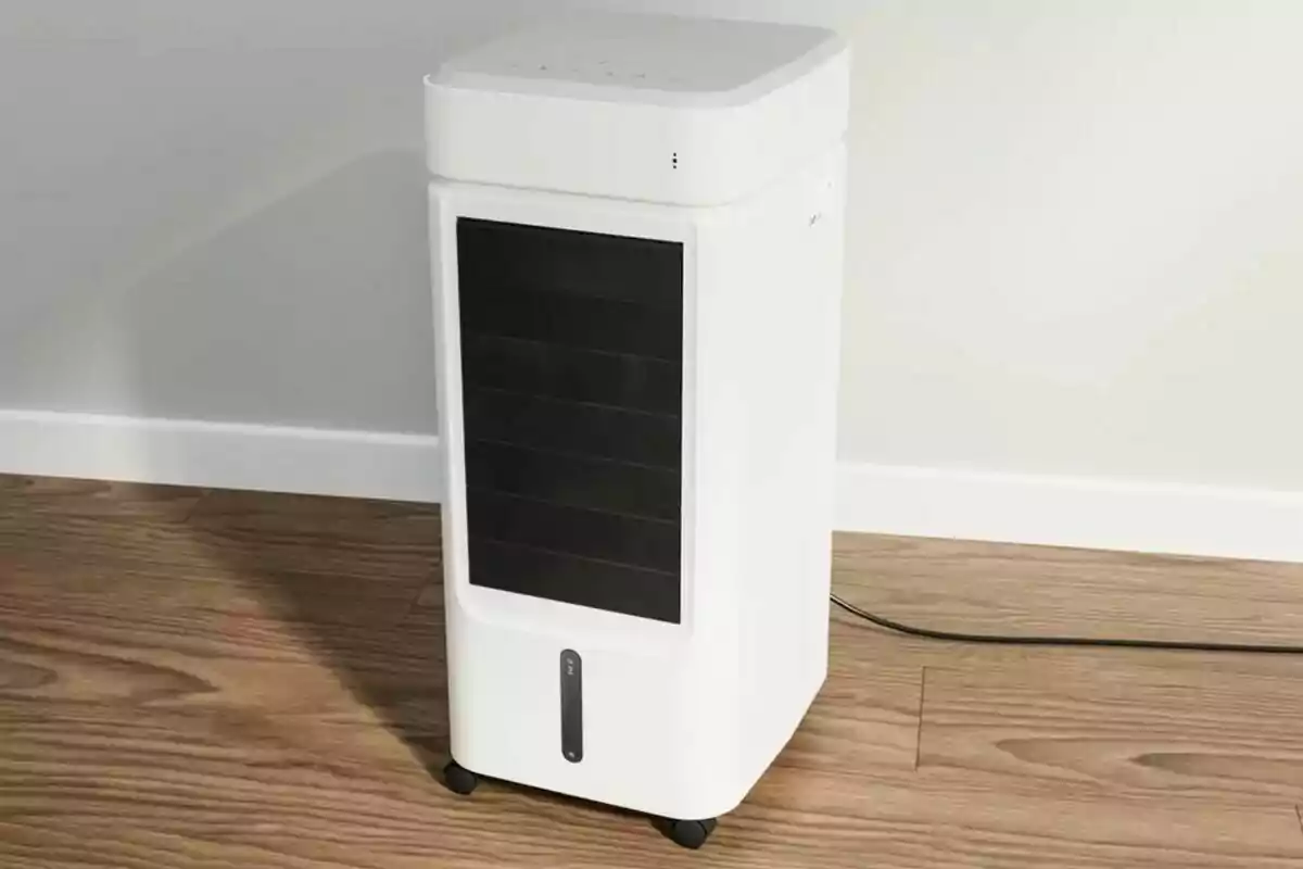 Un refrigerador d'aire portàtil blanc sobre un terra de fusta. Un refrigerador d'aire portàtil blanc sobre un terra de fusta.