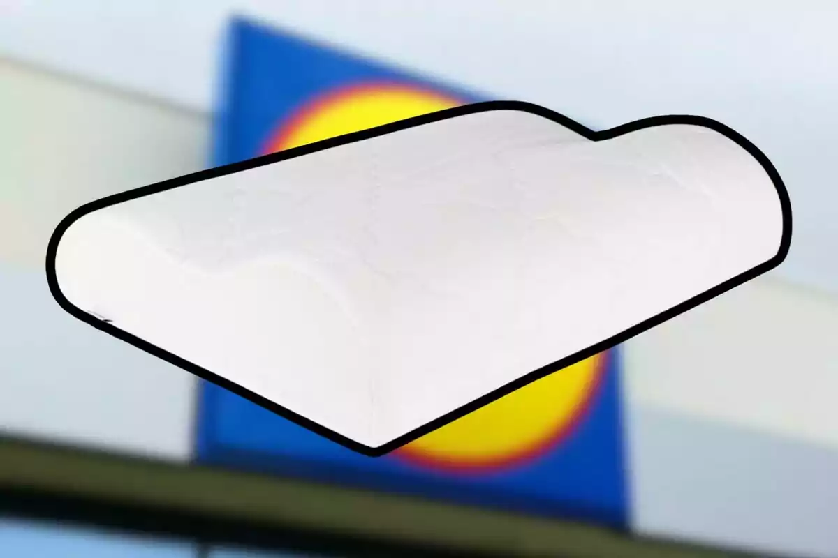 Un coixí ergonòmic blanc amb un fons desenfocat d'un edifici amb un logotip acolorit. Un coixí ergonòmic blanc amb un fons desenfocat d'un edifici amb un logotip acolorit.