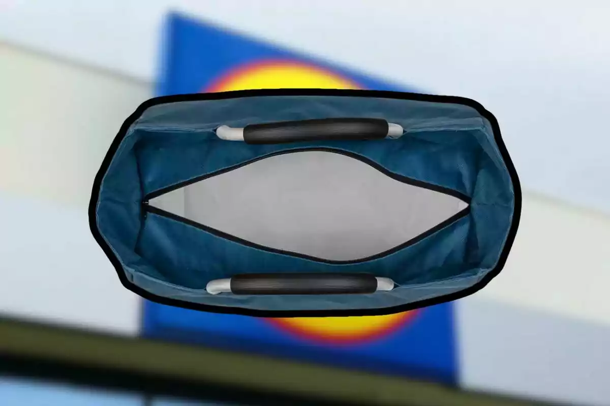 Bossa de compres blava vista des de dalt amb nanses negres i fons desenfocat d’un rètol de supermercat Bossa de compres blava vista des de dalt amb nanses negres i fons desenfocat d’un rètol de supermercat