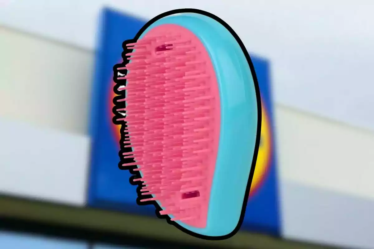 Raspall desembolicador de plàstic en colors rosa i blau amb fons desenfocat d’una botiga Raspall desembolicador de plàstic en colors rosa i blau amb fons desenfocat d’una botiga