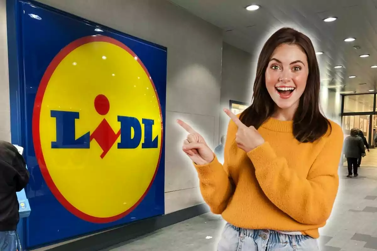 Una dona somrient amb un suèter groc assenyala el logotip de Lidl a l?entrada d?una botiga.