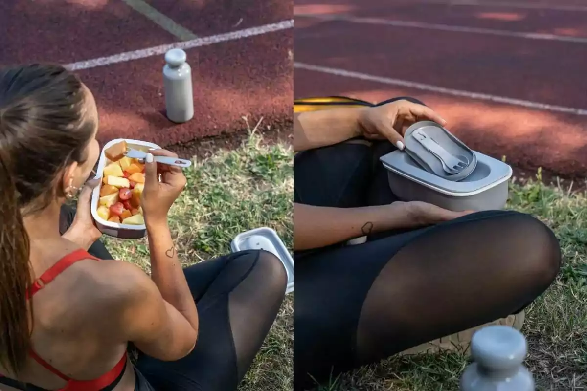 Una persona asseguda a la gespa al costat d'una pista esportiva gaudint d'una amanida de fruites en un recipient mentre sosté una ampolla d'aigua i després tanca el recipient amb una tapa que inclou coberts. Una persona asseguda a la gespa al costat d'una pista esportiva gaudint d'una amanida de fruites en un recipient mentre sosté una ampolla d'aigua i després tanca el recipient amb una tapa que inclou coberts.