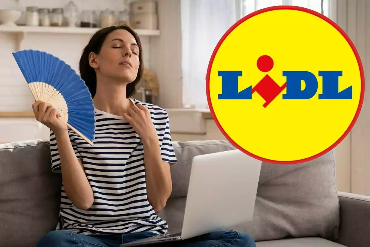 Una dona asseguda en un sofà es ventila amb un ventall blau mentre fa servir un ordinador portàtil, amb el logotip de Lidl superposat a la imatge.