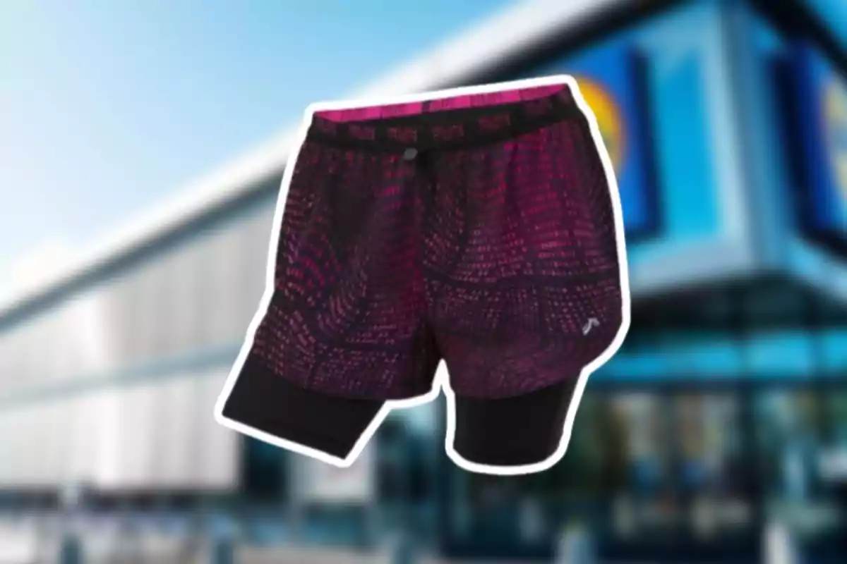 Un parell de pantalons curts esportius amb disseny en tons morats i negres sobre un fons desenfocat d'un edifici modern. Un parell de pantalons curts esportius amb disseny en tons morats i negres sobre un fons desenfocat d'un edifici modern.