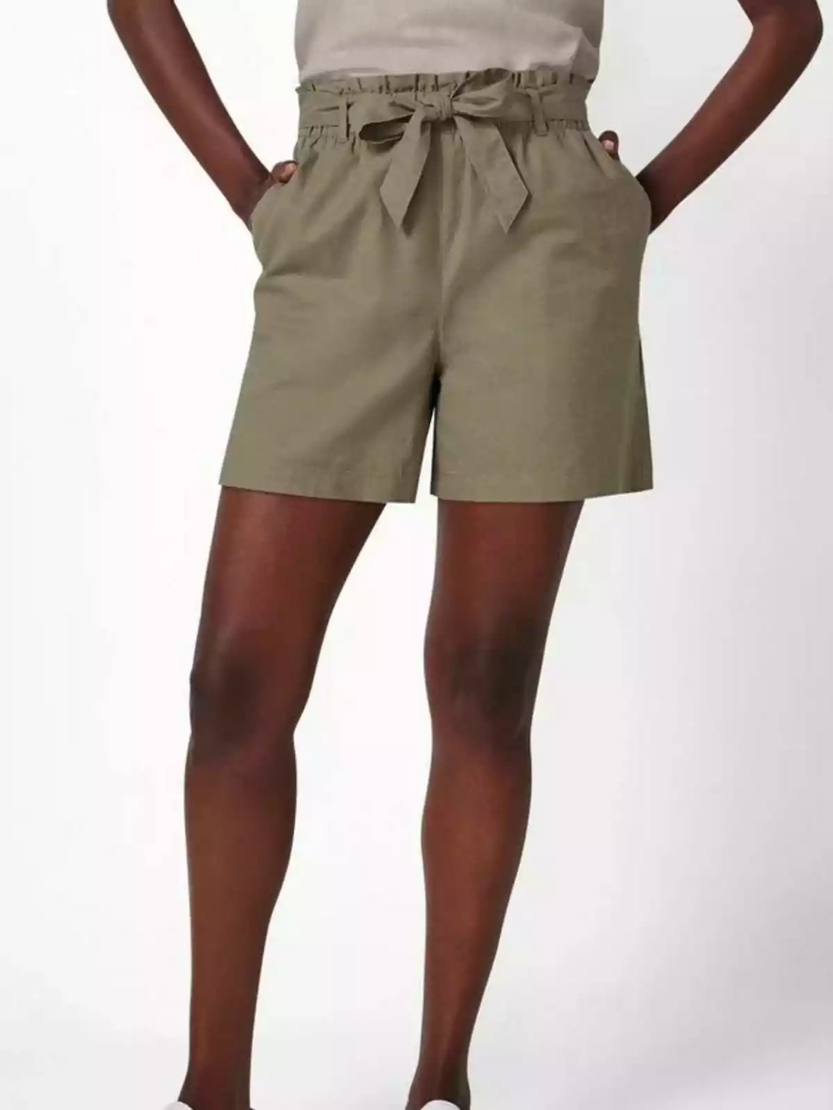 Una persona vestint pantalons curts de color caqui amb un llaç a la cintura. Una persona vestint pantalons curts de color caqui amb un llaç a la cintura.