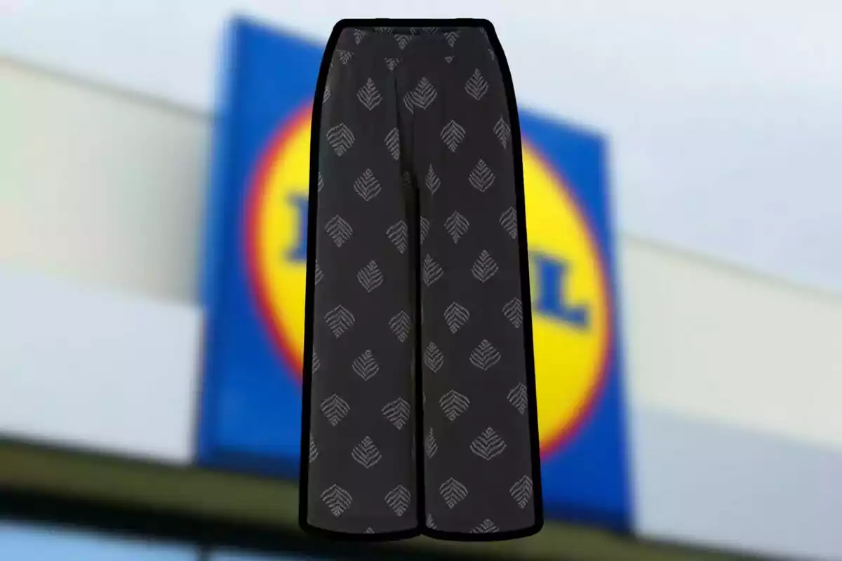 Pantalons negres amb estampat de fulles blanques davant d’un rètol borros d’una botiga. Pantalons negres amb estampat de fulles blanques davant d’un rètol borros d’una botiga.