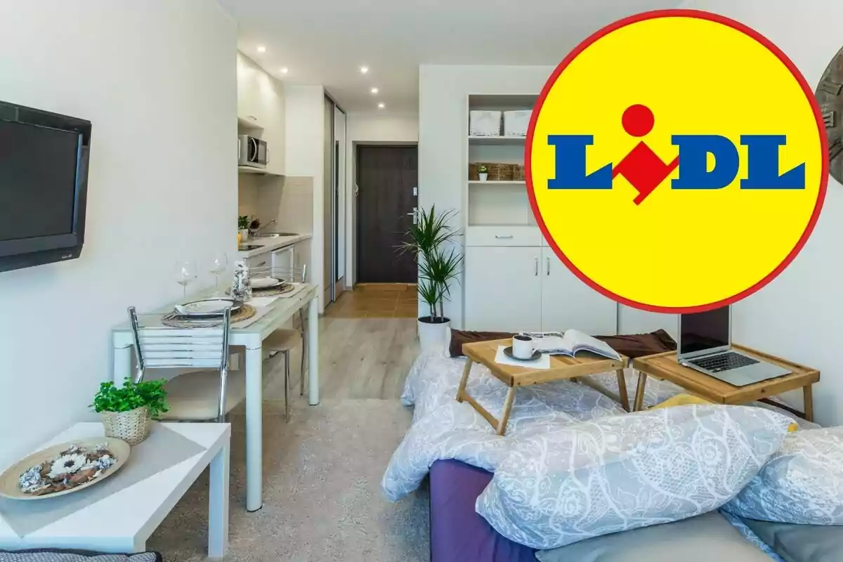 Una habitació moderna i ben il·luminada amb una petita cuina, una taula de menjador i un llit amb safates d'esmorzar, amb el logotip de Lidl superposat a la cantonada dreta.