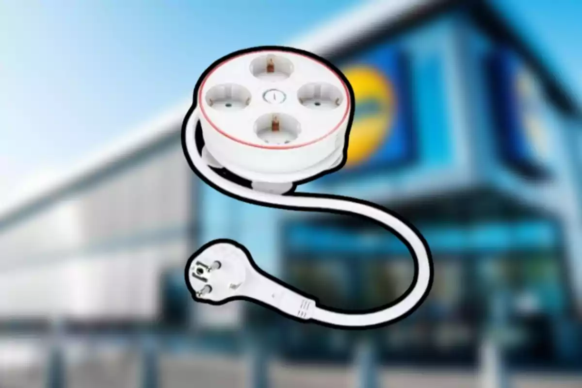 Regleta elèctrica blanca de quatre endolls amb cable sobre un fons desenfocat d’una botiga Regleta elèctrica blanca de quatre endolls amb cable sobre un fons desenfocat d’una botiga