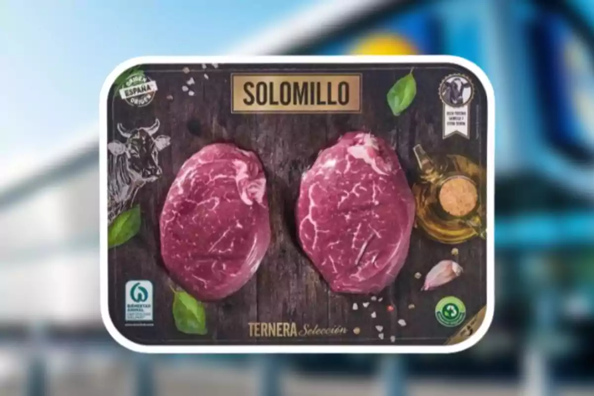 La imatge mostra un paquet de filet de vedella amb dues peces de carn crua en un fons fosc decorat amb fulles verdes, un dibuix de vaca, un recipient d'oli, sal i un gra d'all. La imatge mostra un paquet de filet de vedella amb dues peces de carn crua en un fons fosc decorat amb fulles verdes, un dibuix de vaca, un recipient d'oli, sal i un gra d'all.