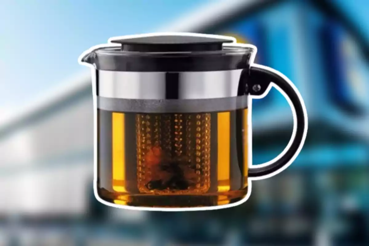 Tetera de vidre amb infusor de metall i tapa negra, conté una beguda de color ambre i està sobre un fons desenfocat. Tetera de vidre amb infusor de metall i tapa negra, conté una beguda de color ambre i està sobre un fons desenfocat.