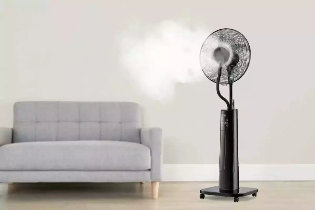 Ventilador negre amb funció d’humidificador encès al costat d’un sofà gris en una sala minimalista Ventilador negre amb funció d’humidificador encès al costat d’un sofà gris en una sala minimalista