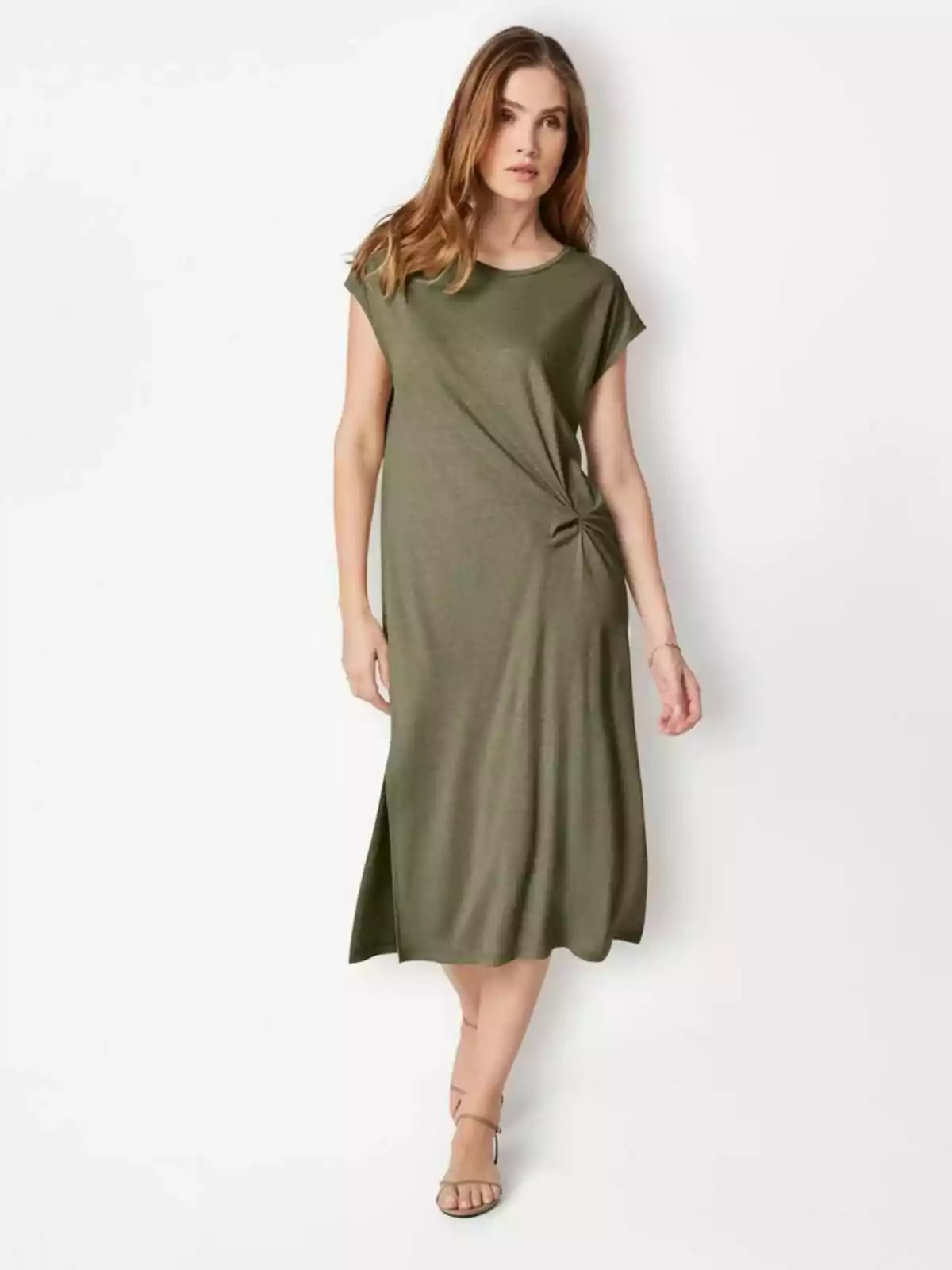 Una dona amb un vestit verd oliva de màniga curta i sandàlies beix. Una dona amb un vestit verd oliva de màniga curta i sandàlies beix.