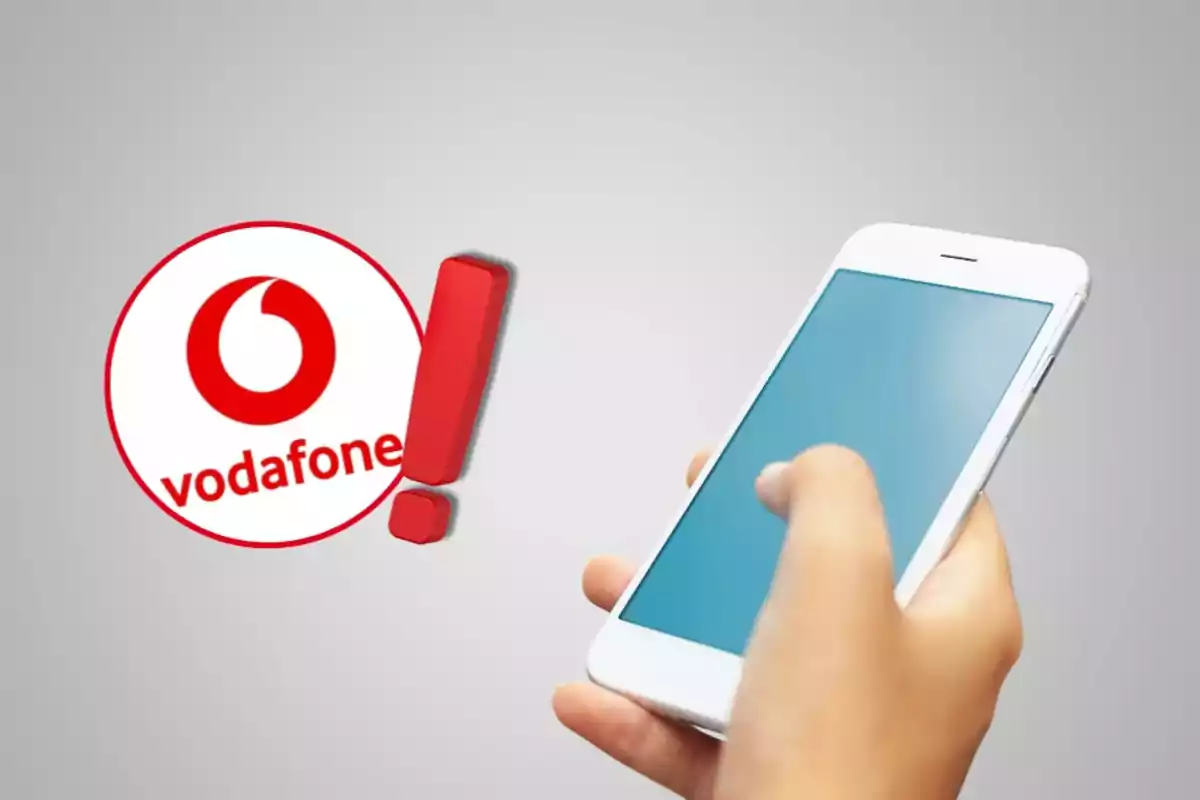 Una mà sostenint un telèfon intel·ligent amb el logotip de Vodafone i un signe d'exclamació vermell al costat.