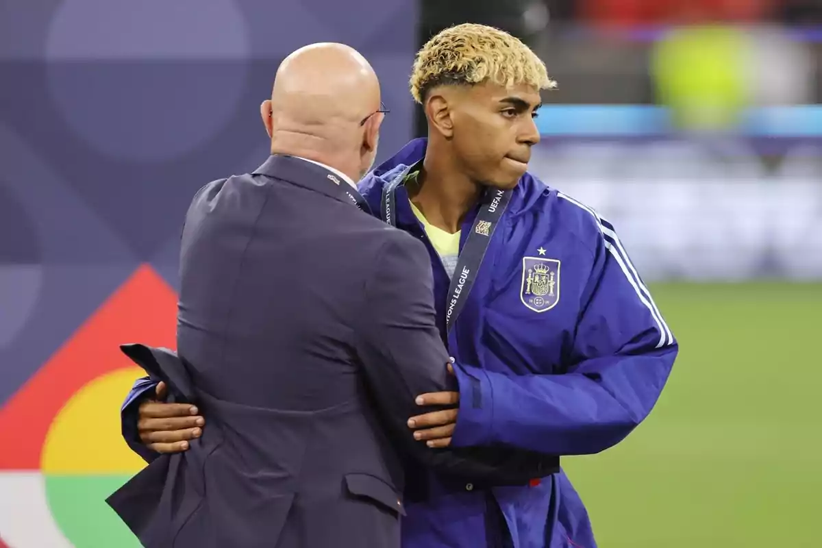 Spanish national soccer team player receiving a medal and being congratulated by a bald man with glasses at a sporting event
