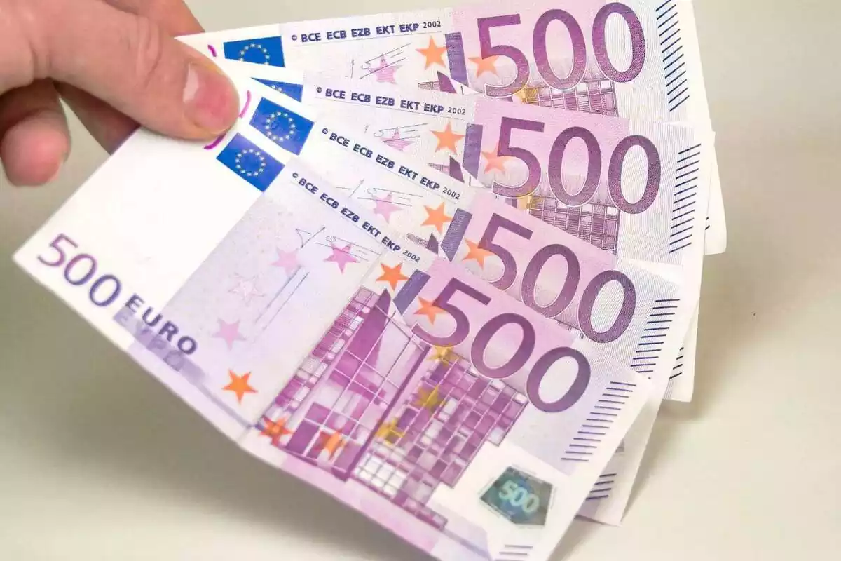 Una mà afagant cuatre bitllets de 500 euros