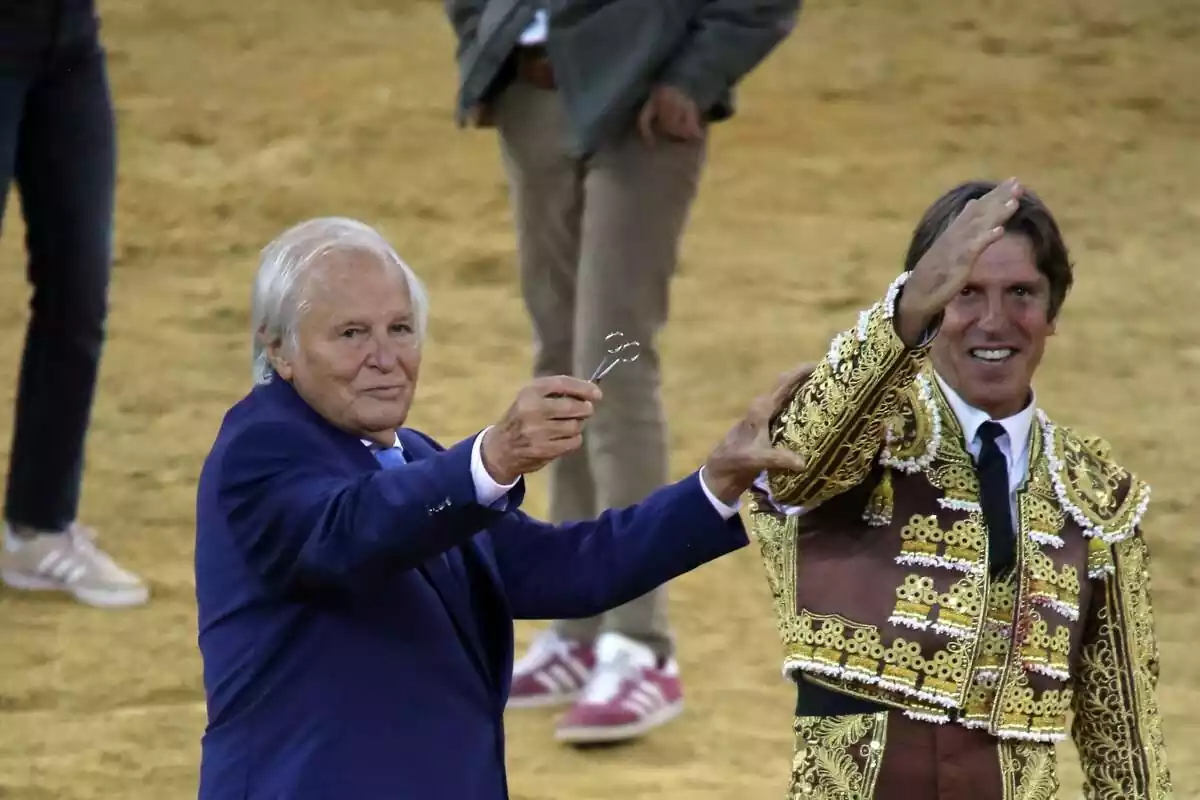 Manuel Benítez en vestit blau i unes tisores a la mà al costat de Manuel Díaz amb la mà a dalt vestit de torero Manuel Benítez en vestit blau i unes tisores a la mà al costat de Manuel Díaz amb la mà a dalt vestit de torero