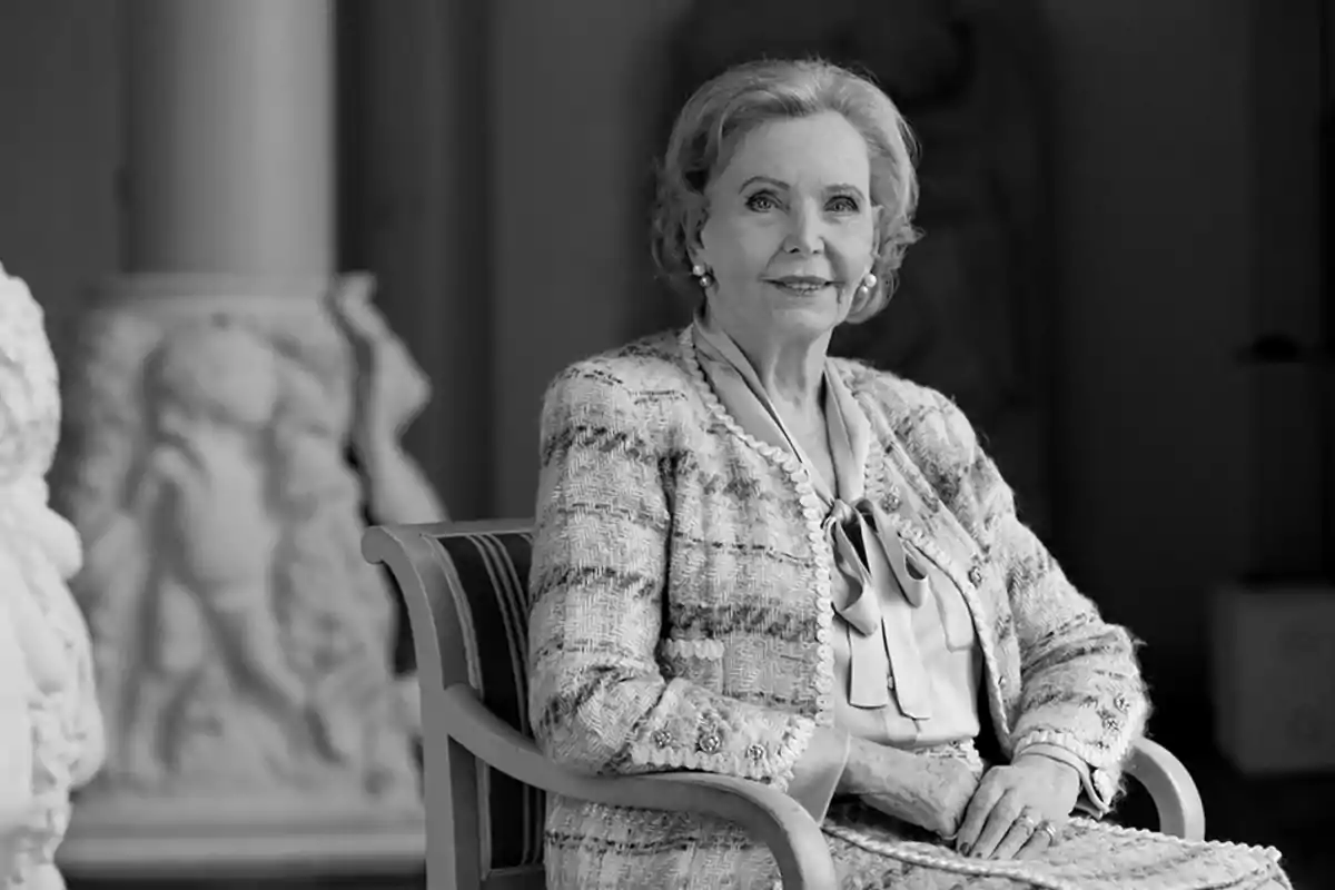 Marianne Bernadotte sitting in a chair wearing an elegant suit in a room decorated with sculptures. Marianne Bernadotte sitting in a chair wearing an elegant suit in a room decorated with sculptures.