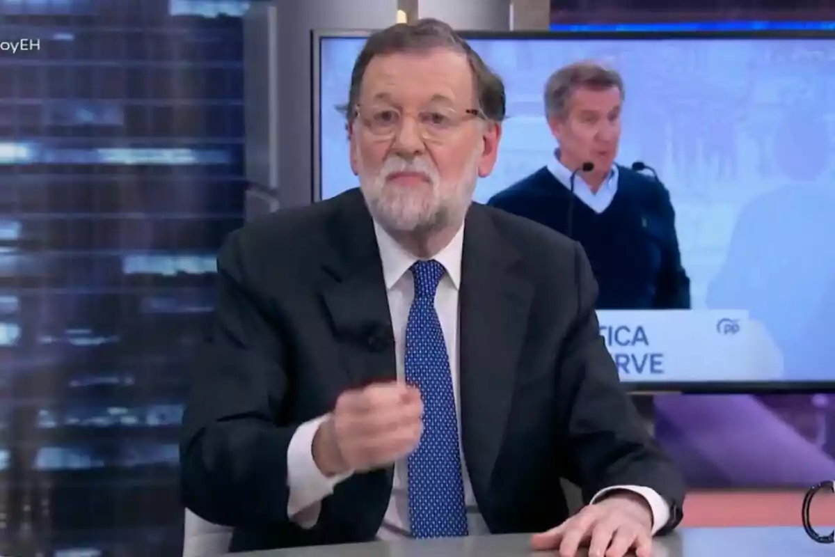 Mariano Rajoy con barba y gafas está sentado en 'El Hormiguero', hablando mientras gesticula con la mano, y en el fondo se ve una pantalla con otra persona hablando en un podio. Mariano Rajoy con barba y gafas está sentado en 'El Hormiguero', hablando mientras gesticula con la mano, y en el fondo se ve una pantalla con otra persona hablando en un podio.