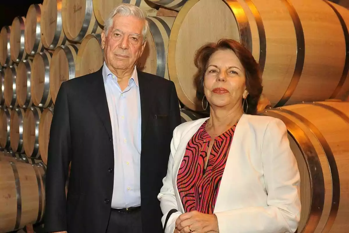 Mario Vargas Llosa i Patricia Llosa posant davant de barrils de fusta en un celler.