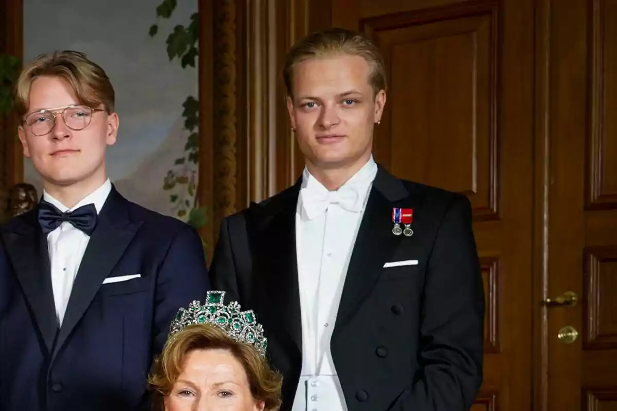 Marius Borg and another man in evening dress pose next to an older woman wearing an emerald tiara. Marius Borg and another man in evening dress pose next to an older woman wearing an emerald tiara.
