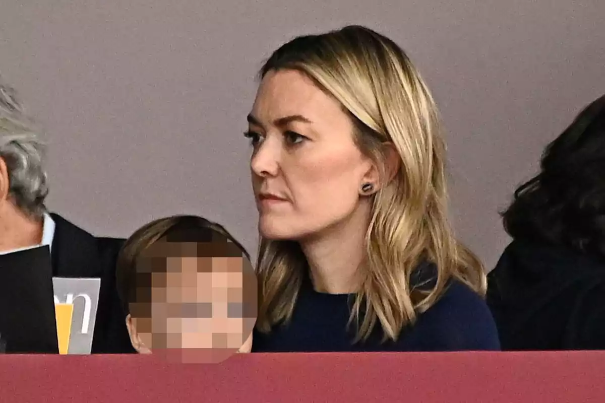 Marta Ortega amb expressió seriosa està asseguda al costat d'un nen el rostre del qual està pixelat. Marta Ortega amb expressió seriosa està asseguda al costat d'un nen el rostre del qual està pixelat.